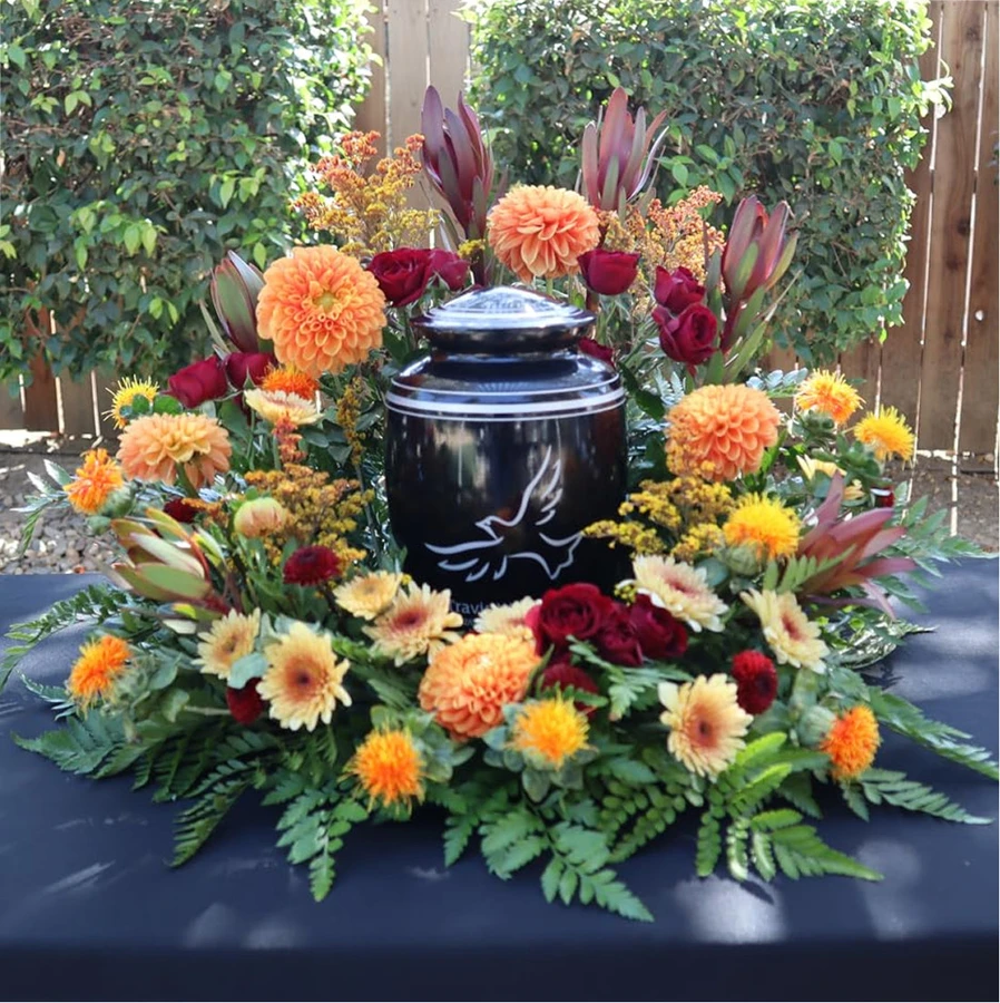 Dove engraving on an urn surrounded by memorial flowers